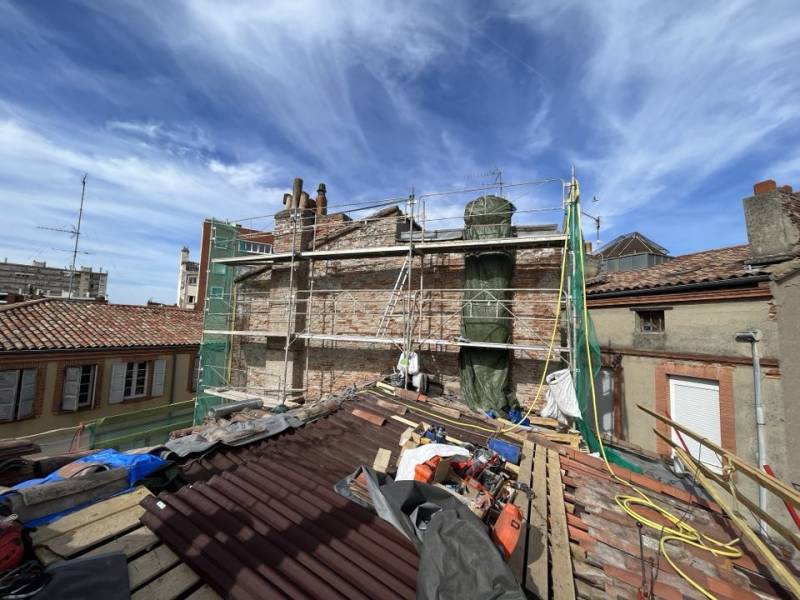 Reprise et réparation d'un pignon mitoyen en brique foraine en toiture à l'aide d'une échafaudage dans le centre ville de Toulouse